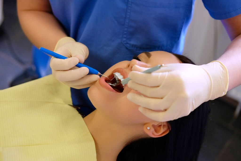 dentist hands working young woman patient with dental tools